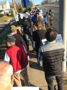Group of people marching down the street with signs.